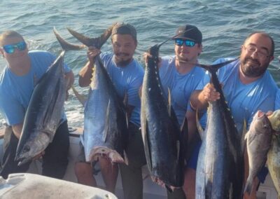 a group of men holding fish on a boat